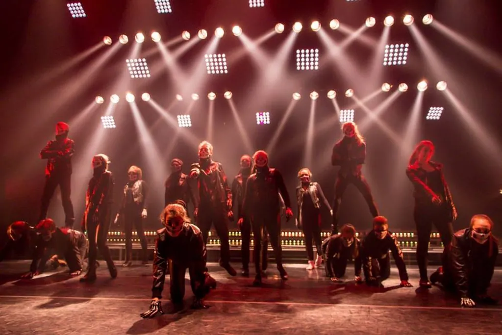 Spectacle de danse contemporaine sous un éclairage rouge intense, grande troupe et mur de projecteurs — conception d’éclairage, Théâtre des Deux Rives, Saint-Jean-sur-Richelieu.