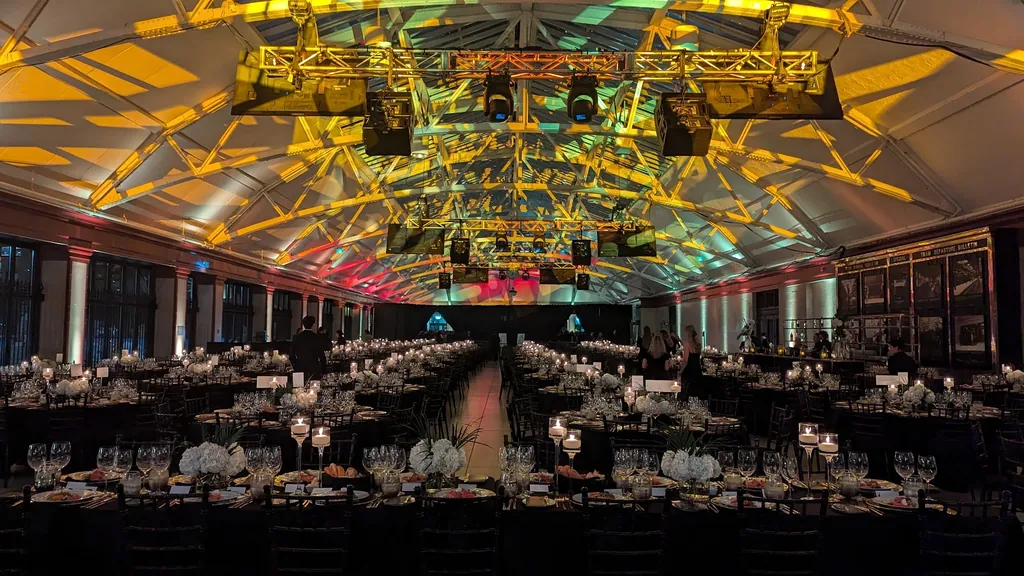 Grande salle de gala dressée sous une structure de truss et projecteurs, éclairage doré et mauve — chef éclairagiste, événement corporatif de haut niveau, Gare Windsor, Montréal.