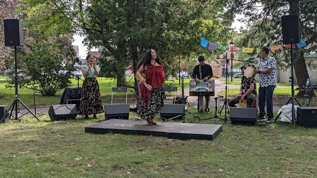 Prestation musicale en plein air dans un parc, chanteuse et musiciens sur une petite estrade — participation technique, événement interculturel avec l’organisme L’Ancre, Saint-Jean-sur-Richelieu.